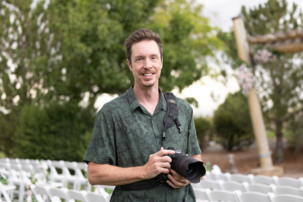 Albuquerque, New Mexico wedding photographer, William Benton, in front of the ceremony site at the Sandia Resort Event Center holding a Canon R5 with a 50mm 1.2 lens