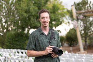 Albuquerque, New Mexico wedding photographer, William Benton, in front of the ceremony site at the Sandia Resort Event Center holding a Canon R5 with a 50mm 1.2 lens